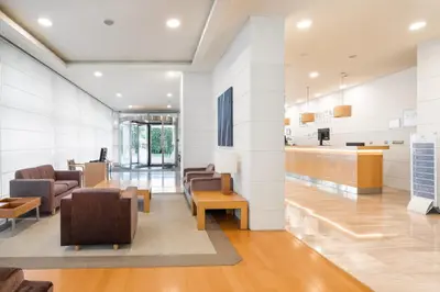 a lobby of a hospital with chairs and a counter at Eurostars San Lazaro in Santiago de Compostela