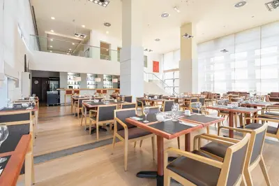 a dining room with wooden tables and chairs at Eurostars San Lazaro in Santiago de Compostela