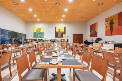a dining room with wooden tables and chairs at Eurostars San Lazaro in Santiago de Compostela
