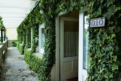 a door to a building covered in ivy at Hotel Virxe da Cerca by Pousadas de Compostela in Santiago de Compostela