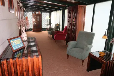 a living room with chairs and a table with a vase at Hotel Virxe da Cerca by Pousadas de Compostela in Santiago de Compostela
