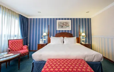a hotel room with a large bed and a desk at Eurostars Araguaney in Santiago de Compostela