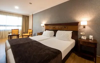 a hotel room with a large bed in a room at Eurostars Araguaney in Santiago de Compostela