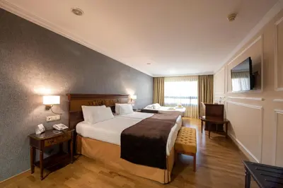 a hotel room with a large bed and a desk at Eurostars Araguaney in Santiago de Compostela