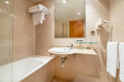 a bathroom with a sink and a bath tub at Dorma Puerta de San Pedro in Lugo