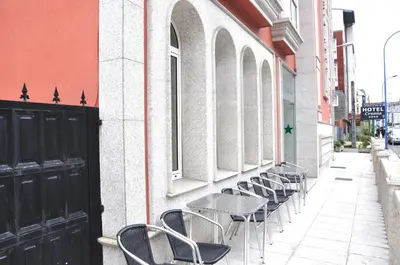 a row of tables and chairs next to a building at Hotel Crunia I A Coruña in A Coruña