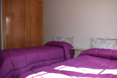 two beds in a room with purple sheets at Tras do convento in Samos