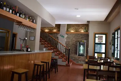 a restaurant with a bar and some tables and chairs at Tras do convento in Samos