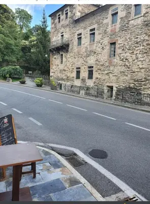 a street with a building and a bench on the side of the road at Tras do convento in Samos
