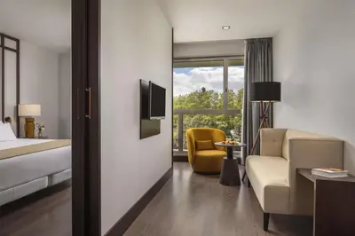 a hotel room with a bed and a couch and a chair at NH Collection Santiago de Compostela in Santiago de Compostela