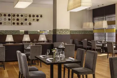 a restaurant with tables and chairs and a bar at NH Collection Santiago de Compostela in Santiago de Compostela