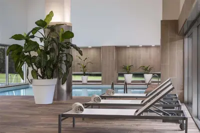a row of benches with plants in a pool at NH Collection Santiago de Compostela in Santiago de Compostela