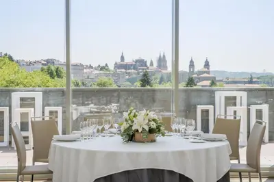 a table with a white table cloth and flowers on it at NH Collection Santiago de Compostela in Santiago de Compostela