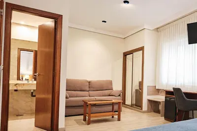 a living room with a couch and a table at Hotel Ciudad de Compostela in Santiago de Compostela