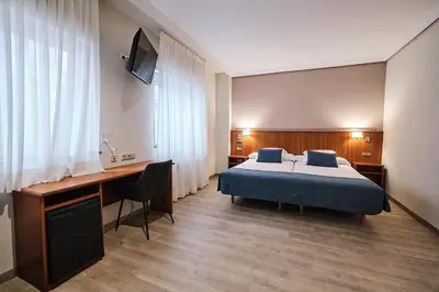 a hotel room with a bed and a desk at Hotel Ciudad de Compostela in Santiago de Compostela