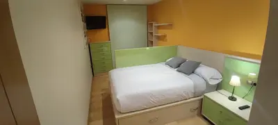 a small bedroom with a bed and a mirror at Piso Estación Termal II in Ourense