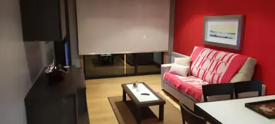 a living room with a red couch and a table at Piso Estación Termal II in Ourense