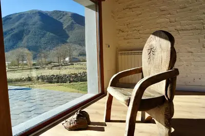 a wooden chair sitting in front of a window at El Parreiro VUT-LE-1607 in Villablino
