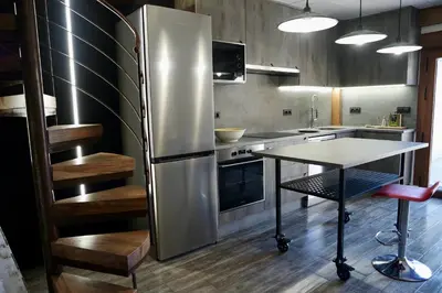 a kitchen with a stainless steel refrigerator and a table at El Parreiro VUT-LE-1607 in Villablino