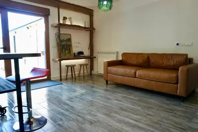 a living room with a brown couch and a table at El Parreiro VUT-LE-1607 in Villablino