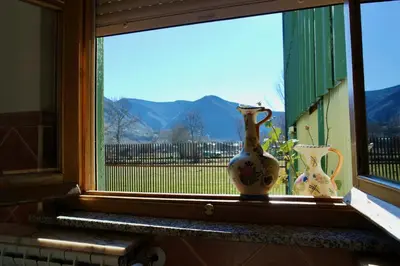 a window with two vases sitting on a window sill at La Furmumecha in Villablino