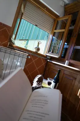 a open book on a table in a kitchen with a window at La Furmumecha in Villablino