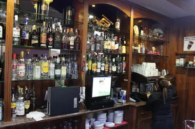 a woman standing at a bar with a computer at Hotel El Castillo in Ponferrada