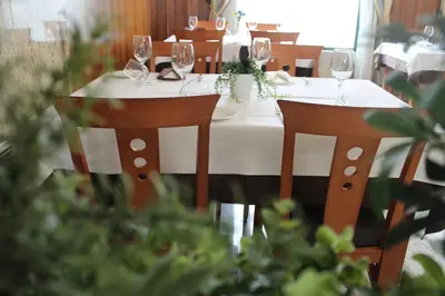 a table with two chairs and wine glasses on it at Hotel El Castillo in Ponferrada