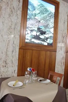 a table with a window and a table with flowers on it at Hotel El Castillo in Ponferrada