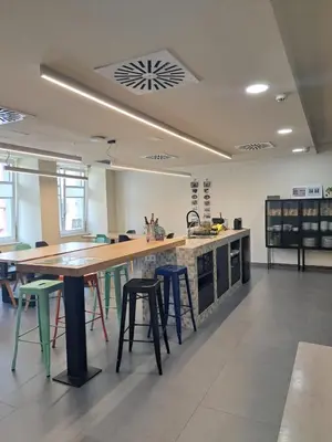 a large kitchen with a large wooden table and stools at LUMEN ALBERGUE in Mondoñedo
