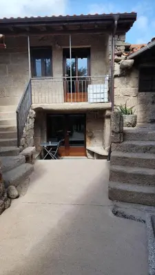 a stone house with a balcony and a patio at Casa Vilar de Flores in Ourense