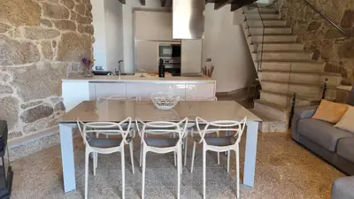 a kitchen and living room with a table and chairs at Casa Vilar de Flores in Ourense