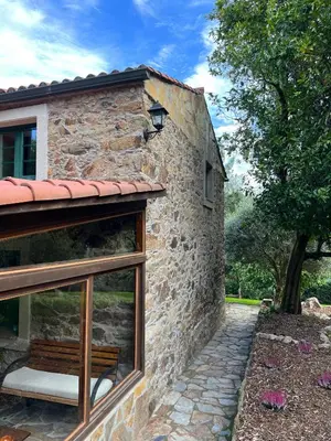 a stone building with a window and a tree at Rural Lambre by Miramar Stays in A Coruña