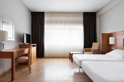 a hotel room with a bed and a desk and a bedroom at Exe Vía Argentum in Silleda