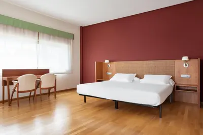 a bedroom with a bed and a desk and a table at Exe Vía Argentum in Silleda