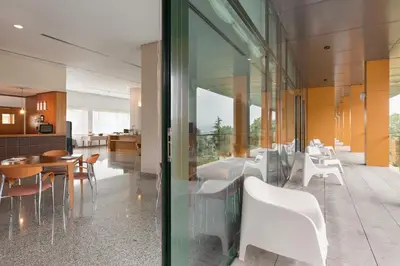 a dining room and kitchen with a glass wall at Exe Vía Argentum in Silleda