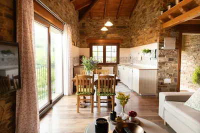 a kitchen and living room with a table and chairs at CASA EL TEIXO in Taramundi