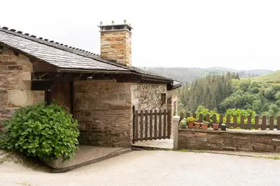 a stone building with a gate and a fence at CASA EL TEIXO in Taramundi