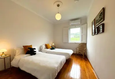 two beds in a room with white walls and a window at Casa Mato in Monforte de Lemos