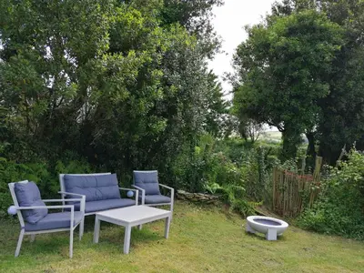 a couple of chairs and a table on a yard at Casa de piedra en pequeña aldea de Ortigueira in Nieves