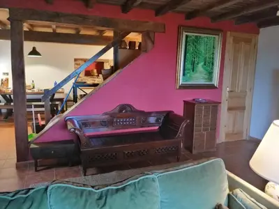 a living room with a couch and a pink wall at Casa de piedra en pequeña aldea de Ortigueira in Nieves
