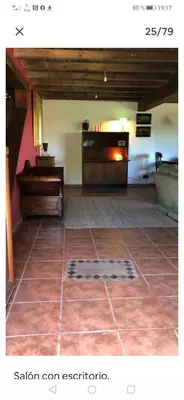 a living room with a piano and a tile floor at Casa de piedra en pequeña aldea de Ortigueira in Nieves