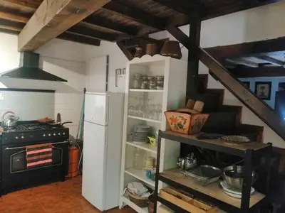 a kitchen with a white refrigerator and a stove at Casa de piedra en pequeña aldea de Ortigueira in Nieves