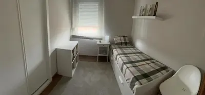 a small room with a bed and a desk at Apartamento en el centro de Viveiro in Vivero