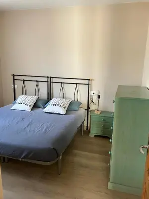 a bedroom with a bed with two pillows and a dresser at A Casa da Fonte in Santa Eulalia de Oscos