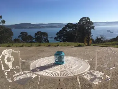 a table and two chairs with a blue vase on it at CASA FONTE DA PEDREIRA in Sada
