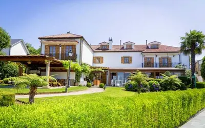 a large white house with a green yard at Pazo do Rio in A Coruña