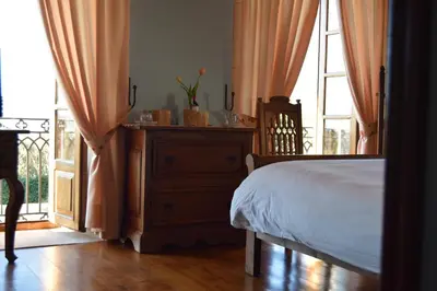 a bedroom with a bed and a dresser and a window at Pazo do Rio in A Coruña