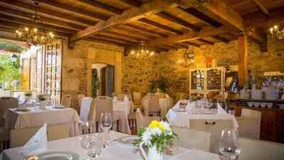 a dining room with white tables and white chairs and a room with at Pazo do Rio in A Coruña