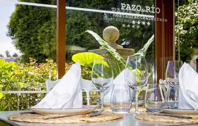 a table with wine glasses and napkins on it at Pazo do Rio in A Coruña